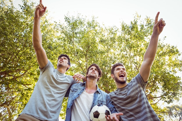 Foto amigos felices en el parque con fútbol