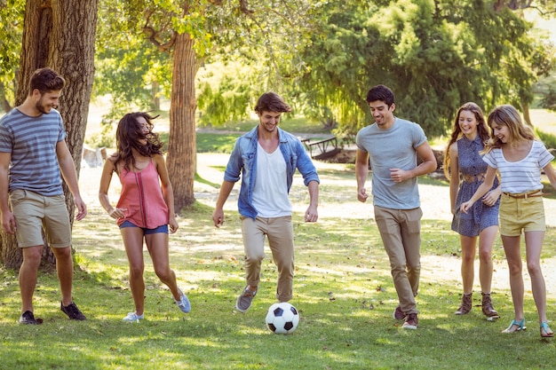 Amigos felices en el parque con fútbol