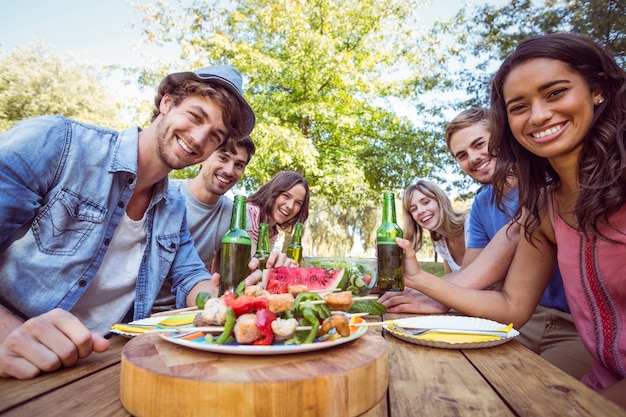 Amigos felices en el parque con picnic