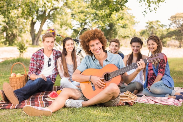 Amigos felices en el parque con picnic