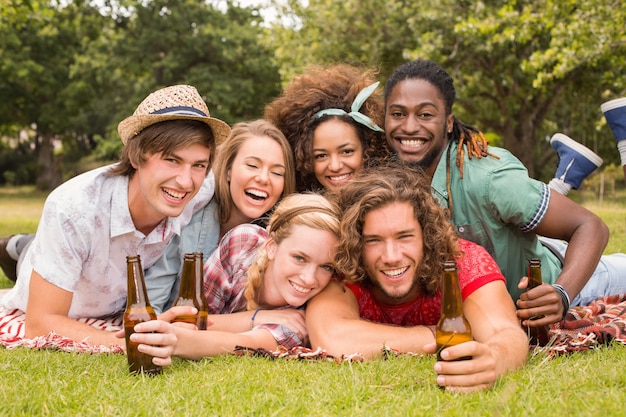 Amigos felices en el parque con picnic