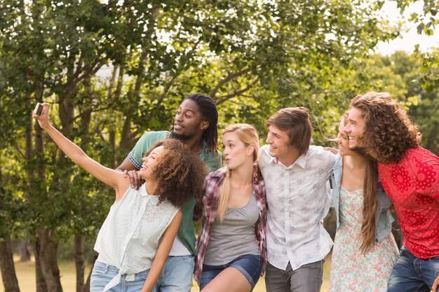 Amigos felices en el parque tomando selfie