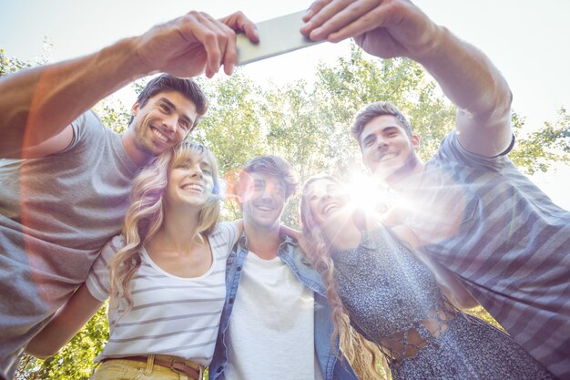 Amigos felices en el parque tomando selfie