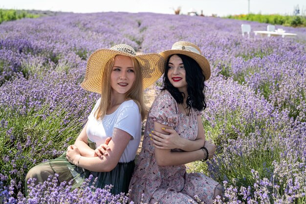 Amigos felices posando junto con flores de lavanda en un campo grande