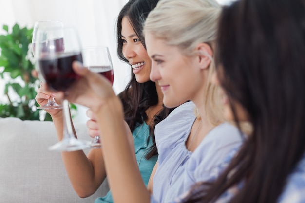 Foto amigos felices que tienen vino tinto juntos