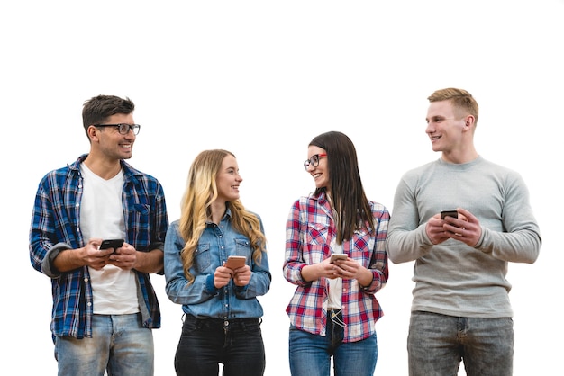 Foto los amigos felices con teléfonos están parados en el fondo blanco.