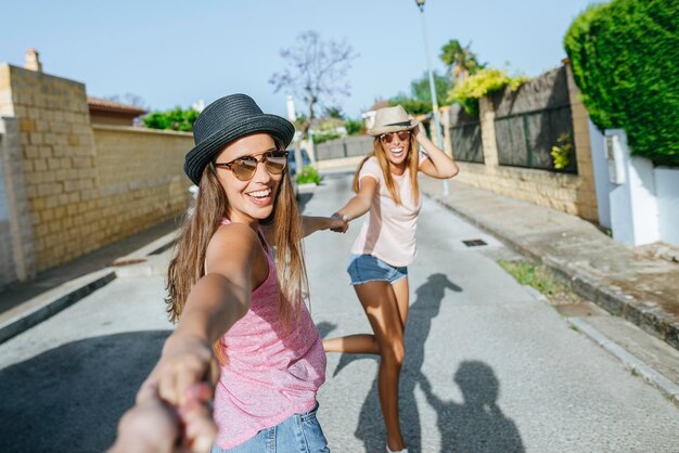 Amigos felices tomados de la mano en la calle