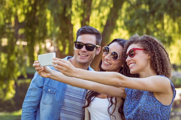 Amigos felices tomando una selfie en el parque