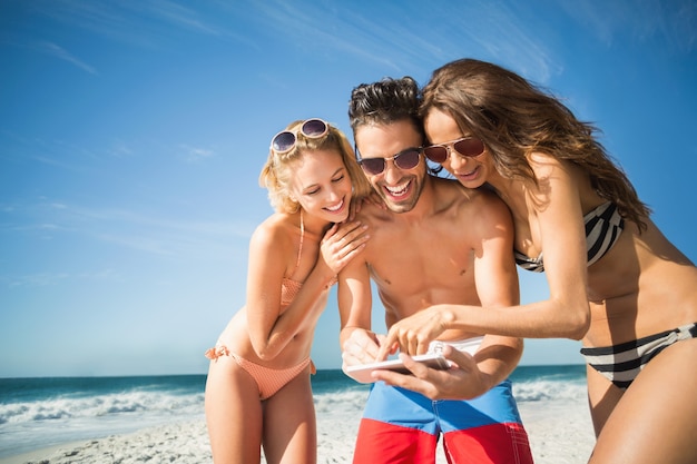 Amigos felices tomando selfie en la playa