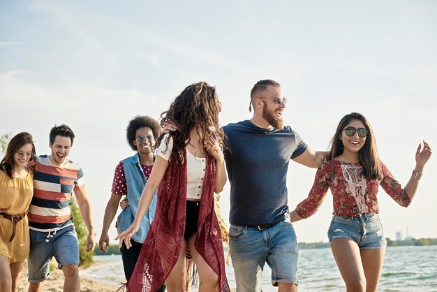 Amigos felizes a caminhar na praia