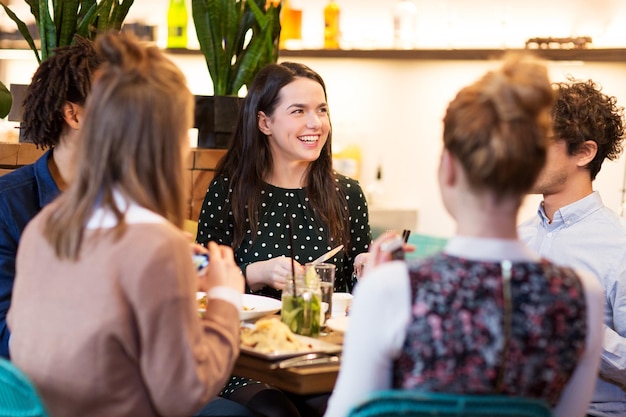 amigos felizes a comer num bar ou restaurante