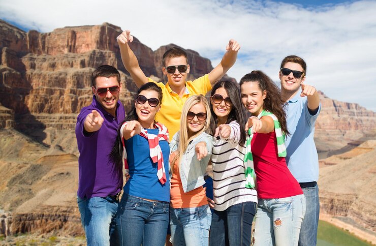 Foto amigos felizes apontando para você sobre o grand canyon