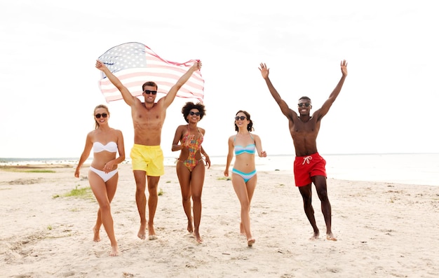 Foto amigos felizes com bandeira americana na praia de verão