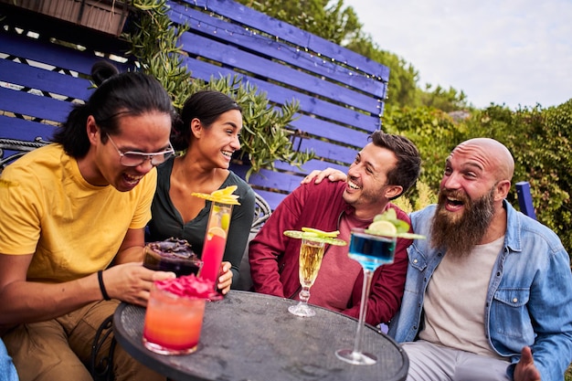 Amigos felizes comemorando bebendo coquetéis grupo de jovens sorridente se divertindo terraço bar