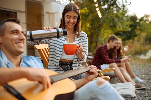 Amigos felizes descansando em um piquenique, fim de semana em um acampamento na floresta