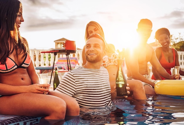 Foto amigos felizes desfrutando de bebidas na piscina