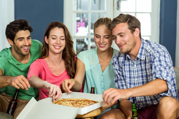 Amigos felizes desfrutando de pizza