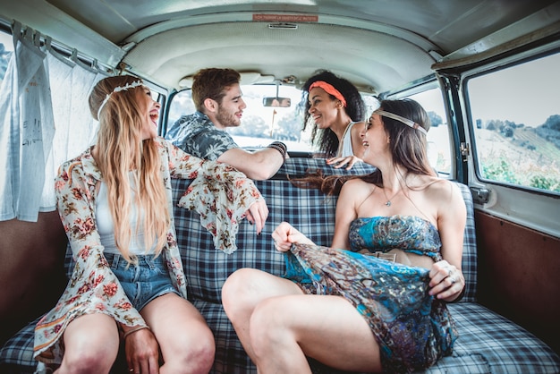 Amigos felizes dirigindo uma minivan vintage