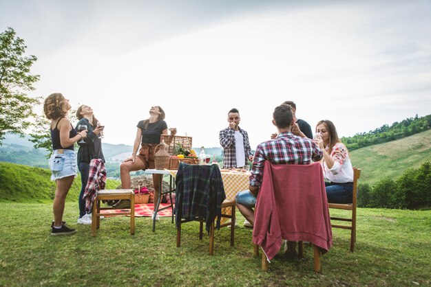 Amigos felizes fazendo churrasco ao ar livre