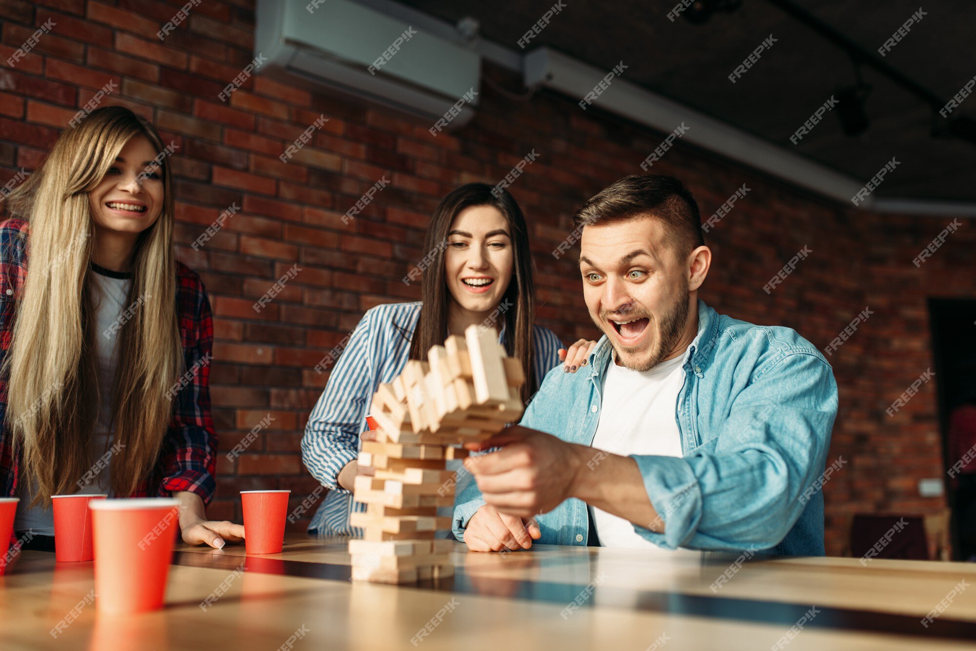 Amigos Jogando Cartas Sentadas Em Uma Mesa, Jovens Se Divertindo Juntos Em  Casa Ou Café. Pessoas Felizes Estão Descansando, Bebendo Bebidas Com Doces  E Jogando Um Jogo De Tabuleiro. Jogos De Família