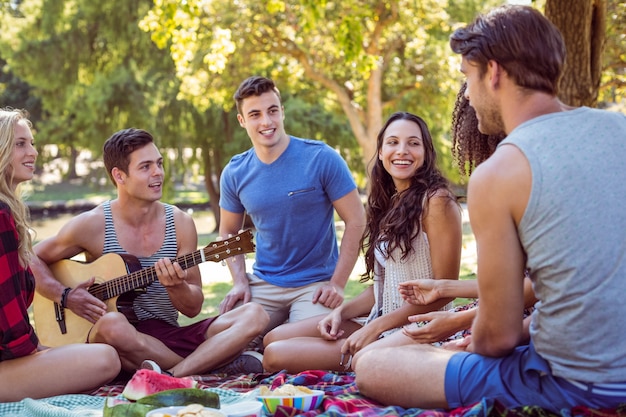 Amigos felizes no parque com piquenique