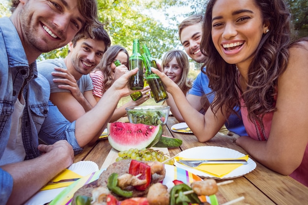 Amigos felizes no parque com piquenique