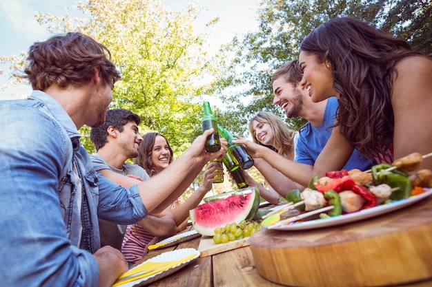 Amigos felizes no parque com piquenique