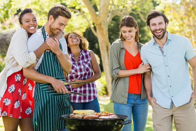 Foto amigos felizes, preparando uma churrasqueira no parque