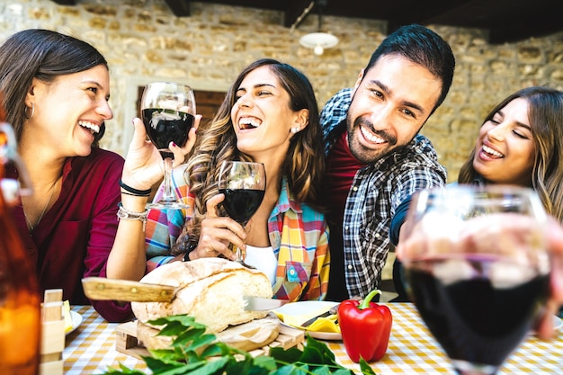 Amigos felizes se divertindo bebendo vinho tinto no bar da fazenda