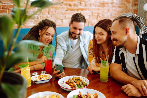 Amigos felizes se divertindo no café Jovens sentados em uma restauração se divertindo juntos