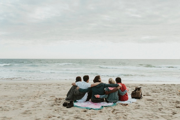 Amigos felizes sentados juntos na praia