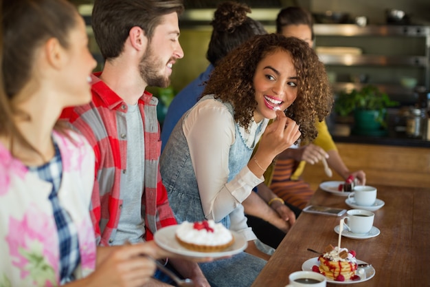 Amigos felizes tendo sobremesa no restaurante