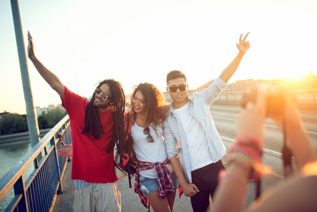 Amigos felizes tirando fotos uns dos outros ao ar livre no verão. Viagem, férias, férias, conceito de viagem.