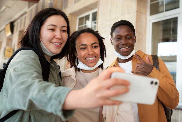 Foto amigos felizes tirando selfie em foto média