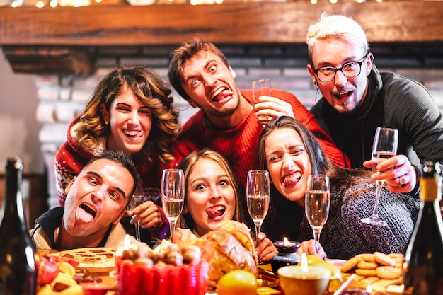 Foto amigos felizes tirando selfies bêbados e loucos para comemorar o natal com champanhe