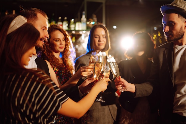 Amigos felizes, torcendo e bebendo coquetéis, curtindo a festa no clube Conceito de estilo de vida da juventude