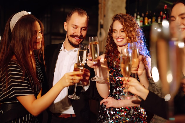 Amigos felizes, torcendo e bebendo coquetéis, curtindo a festa no clube Conceito de estilo de vida da juventude