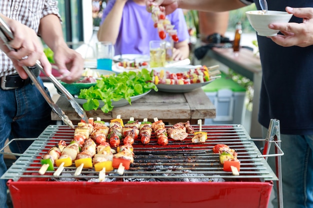 Amigos, festa e cozinhar churrasco em Gardern.