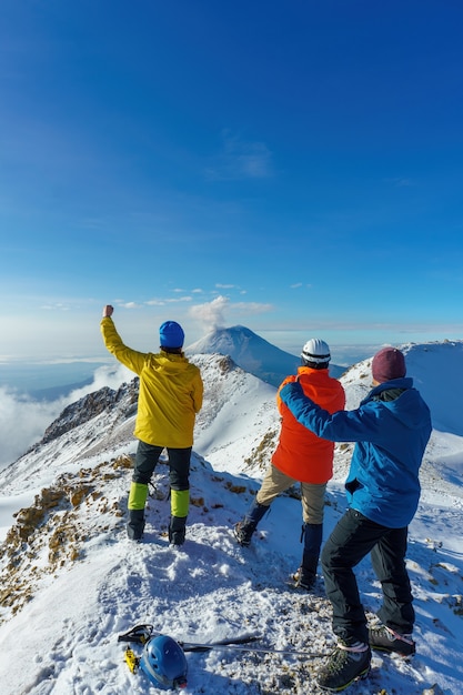 Amigos fica no topo de uma montanha olhando para as montanhas