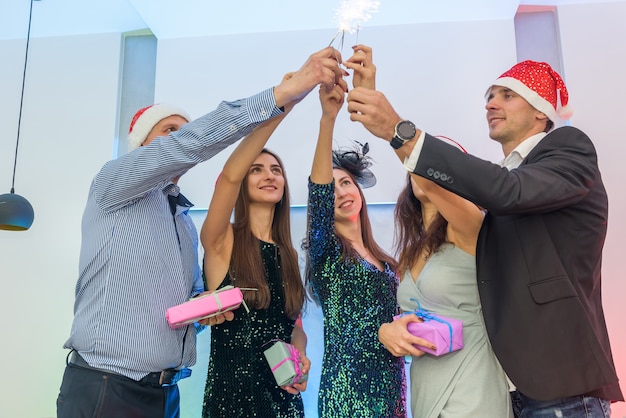 Foto amigos en la fiesta de año nuevo disparando luces de bengala todos juntos