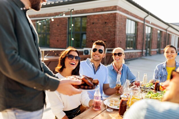 amigos en una fiesta de barbacoa en la azotea en verano