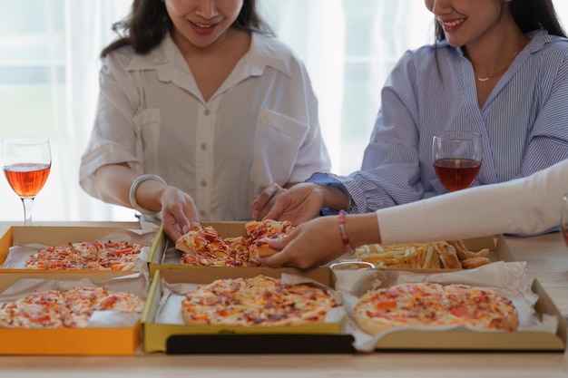 Amigos en la fiesta de cumpleaños tintineo de copas con champán y pizza disfrutando de la pizza navideña en la mesa Evento de fiesta navideña