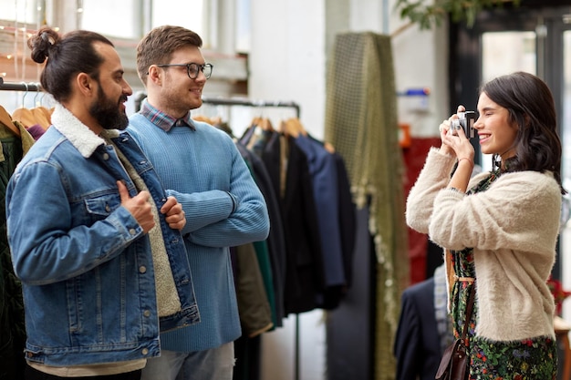 amigos fotografando em loja de roupas vintage