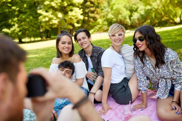 amigos fotografando em um piquenique no parque de verão