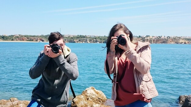 Foto amigos fotografando na costa contra o céu