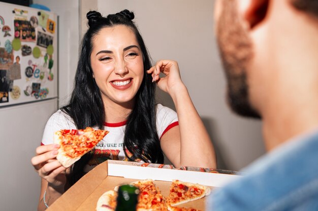 Amigos de frente comiendo pizza