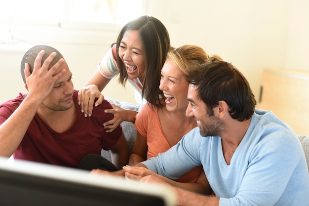 Amigos en frente de la televisión viendo el juego