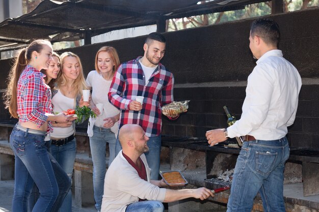 Amigos fritando carne ao ar livre