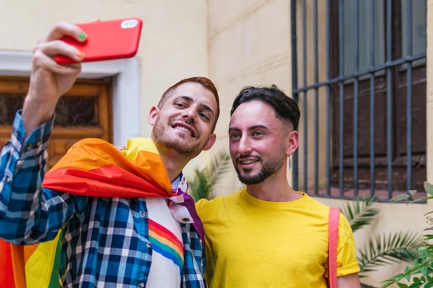Amigos gays alegres abraçando orgulho captura selfie vibrante saindo de casa