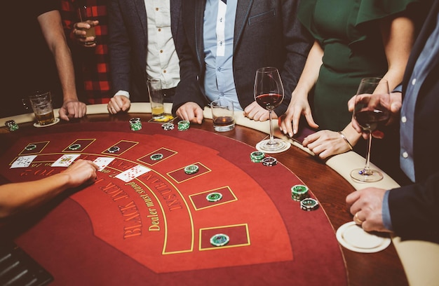 Los amigos de la gente juegan a la ruleta de póquer en la mesa del casino Procesamiento de fotos antiguas